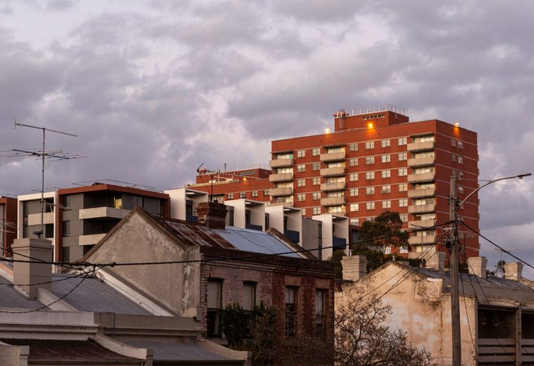 A Sydney streetscape features modern apartments, historic terrace houses and public housing high rises.